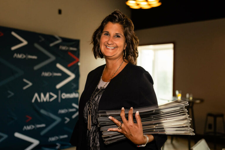 Woman holds awards from the AMA Omaha Pinnacle Awards.