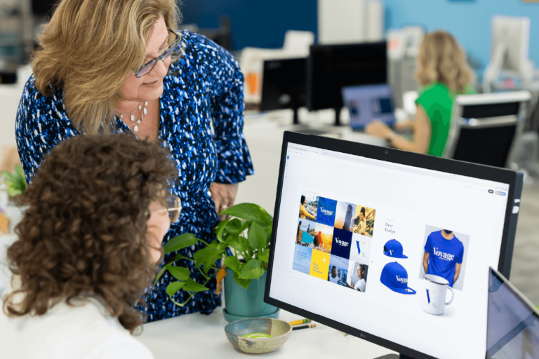 In the KidGlov office, Lyn Wineman looks over the shoulder of Ashley to view the Voyage Healthcare style guide.