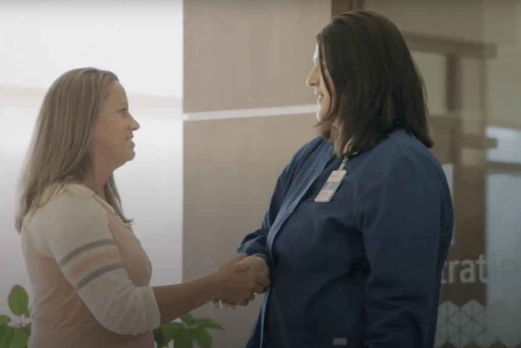 Image of a woman shaking her doctors hand. Image pulled from Great Planes Health Spinal Care TV spot.