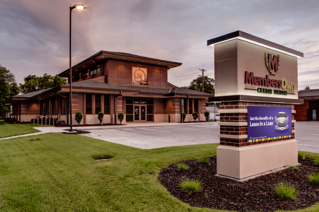 Image of the exterior of MembersOwn Credit Union. The Auto Loans campaign banner is out front on the sign.