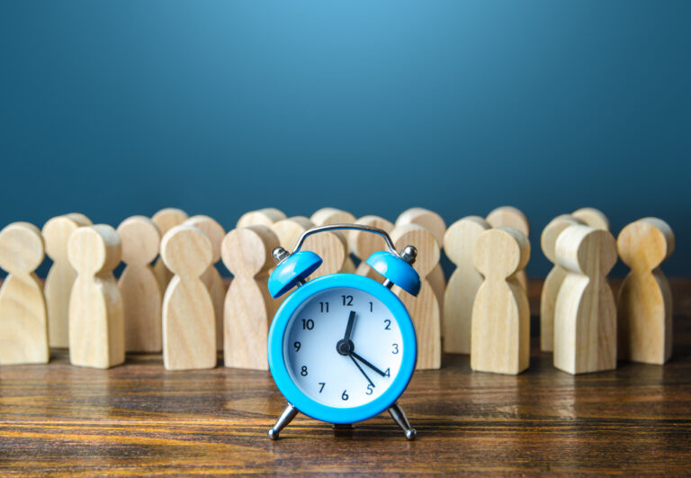 blue clock in front of wooden people