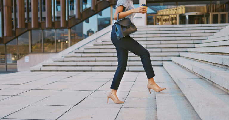 Shot of an unrecognizable businesswoman walking up a staircase in the city